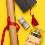 Graduation hat, money, and diploma on a yellow background