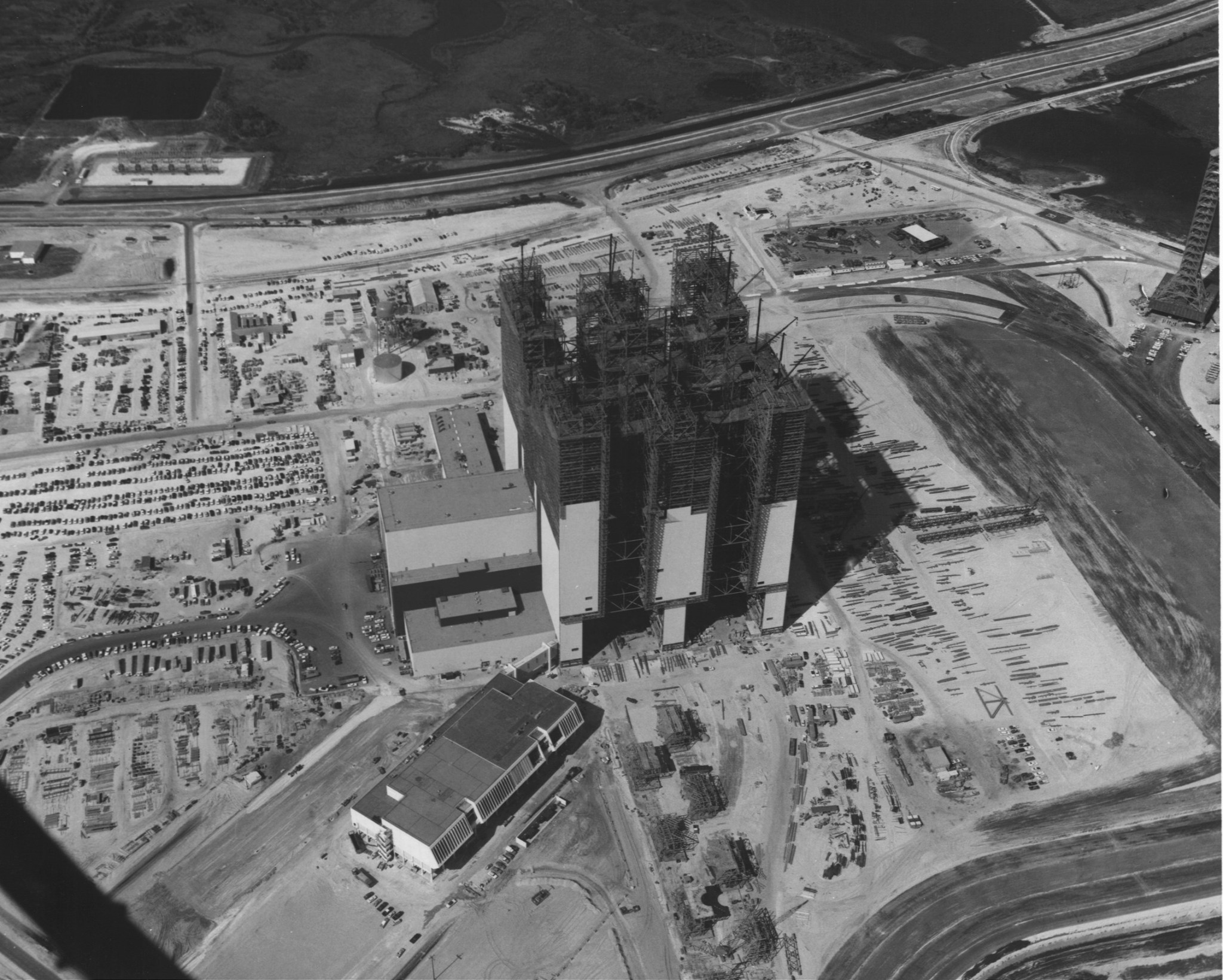 An aerial view of the Vehicle Assembly Building (VAB) during construction in 1965 at NASA’s Kennedy Space Center in Florida. In front of the VAB is the Launch Control Center.