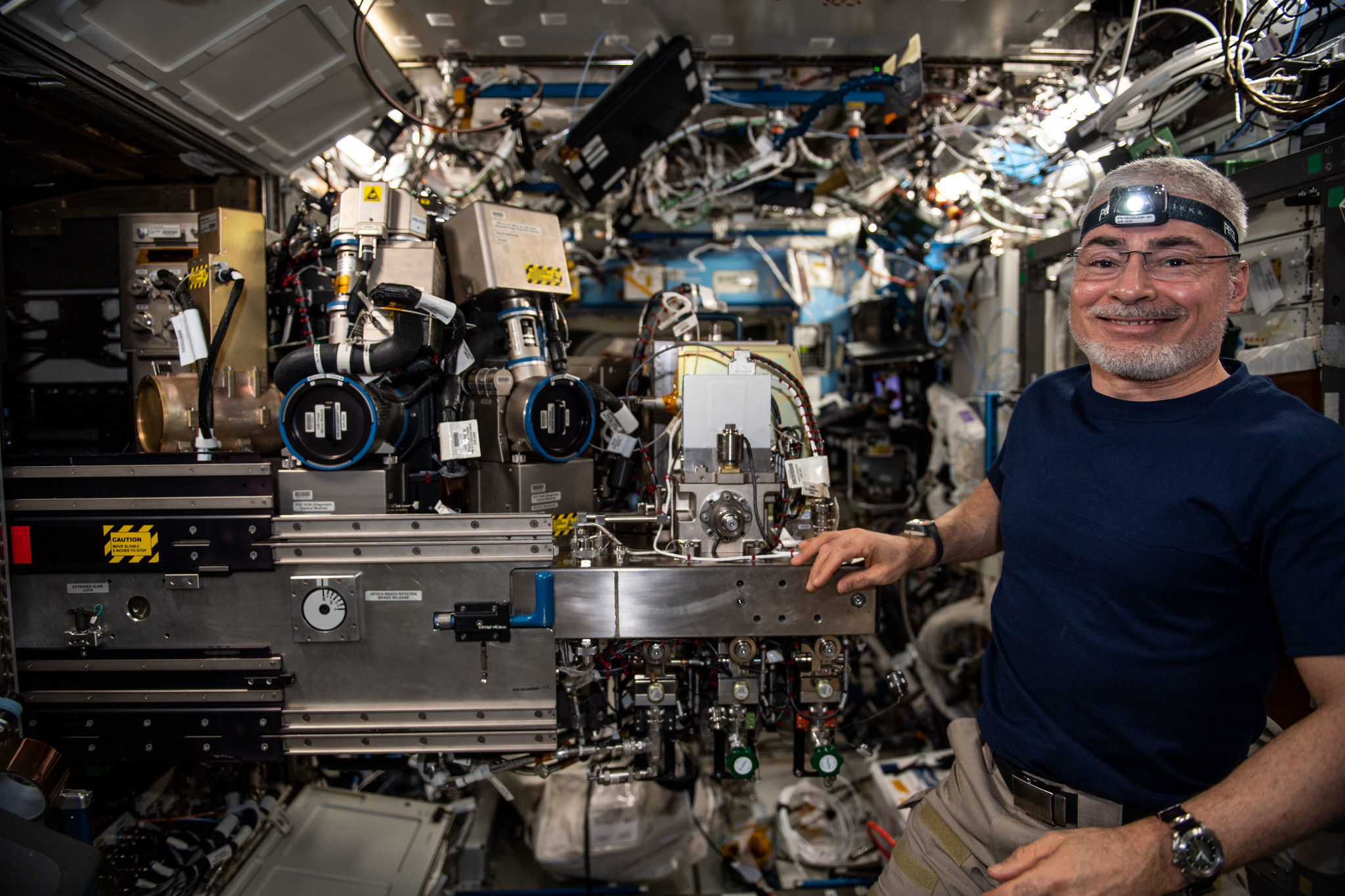 image of astronaut posing with experiment hardware