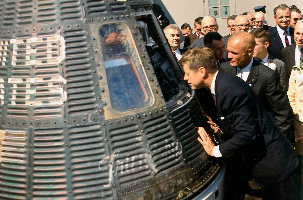 President John F. Kennedy peers inside Friendship 7 as astronaut John H. Glenn looks on