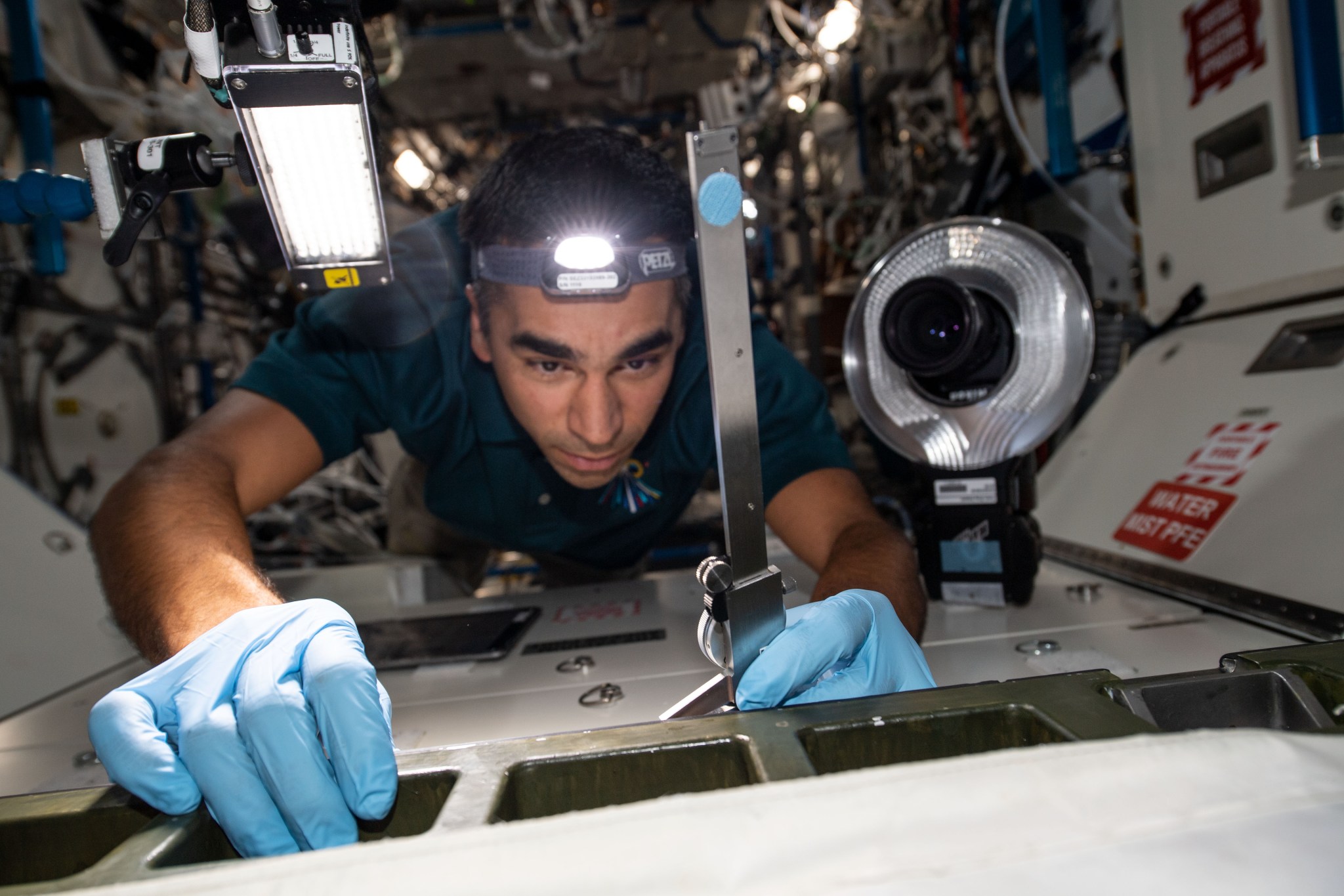 NASA astronaut and Expedition 66 Flight Engineer Raja Chari inspects hatch seals aboard the International Space Station's U.S. Destiny laboratory module Dec. 17, 2021.