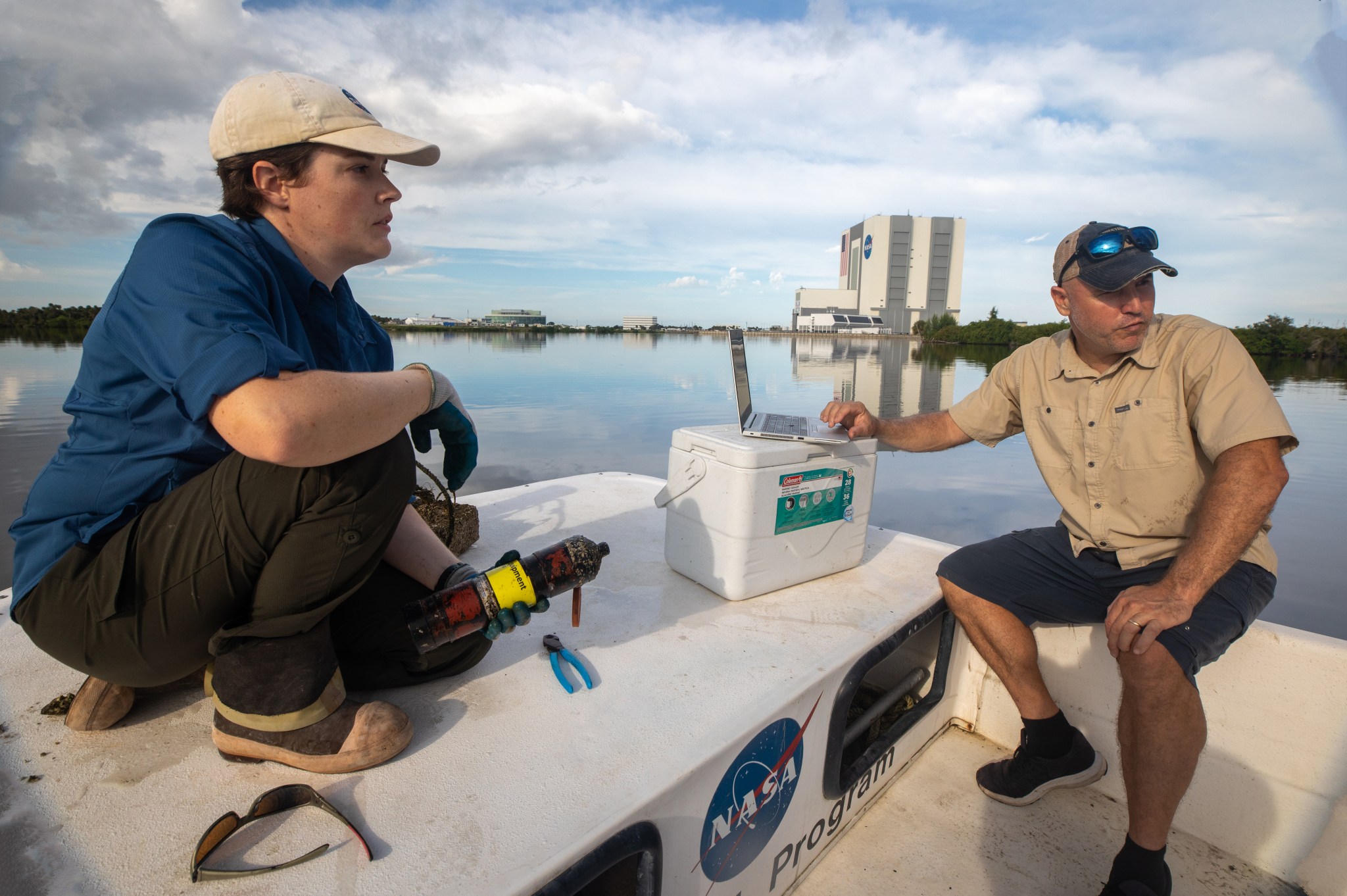 Fisheries biologists Bonnie Ahr and Eric Reyier service an acoustic receiver near the Vehicle Assembly Building that is deployed to monitor the local movements of tagged sportfish and sea turtles. 