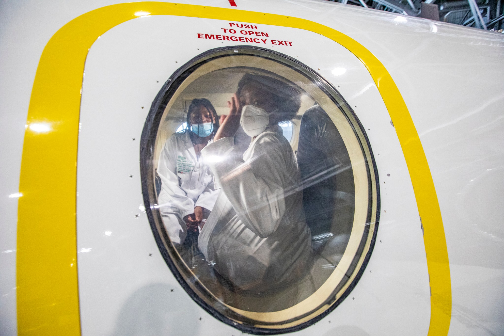 NSBE Jr. members Nia Williamson, left, and Skylar Montaque wave inside a research plane during a tour of NASA Langley Feb. 24.