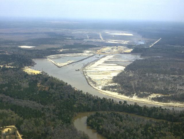 An aerial view shows early construction of the Mississippi Test Operations in 1963. The waterway shown is the first leg of the 7 and 1/2 mile long canal system. The East Pearl River is shown at extreme bottom of photo.