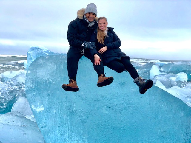 Waryn and Richmon sitting on a large block of ice with a sea behind them.