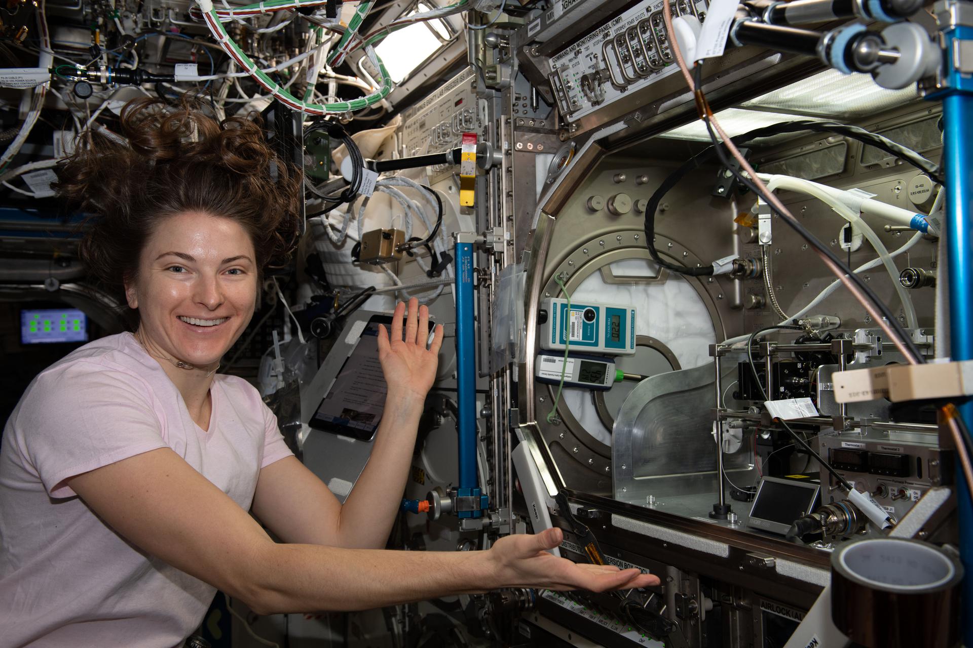 image of an astronaut setting up hardware for an experiment