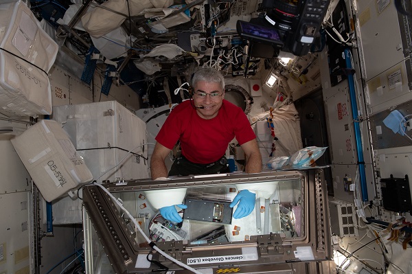 image of an astronaut working with a science glovebox