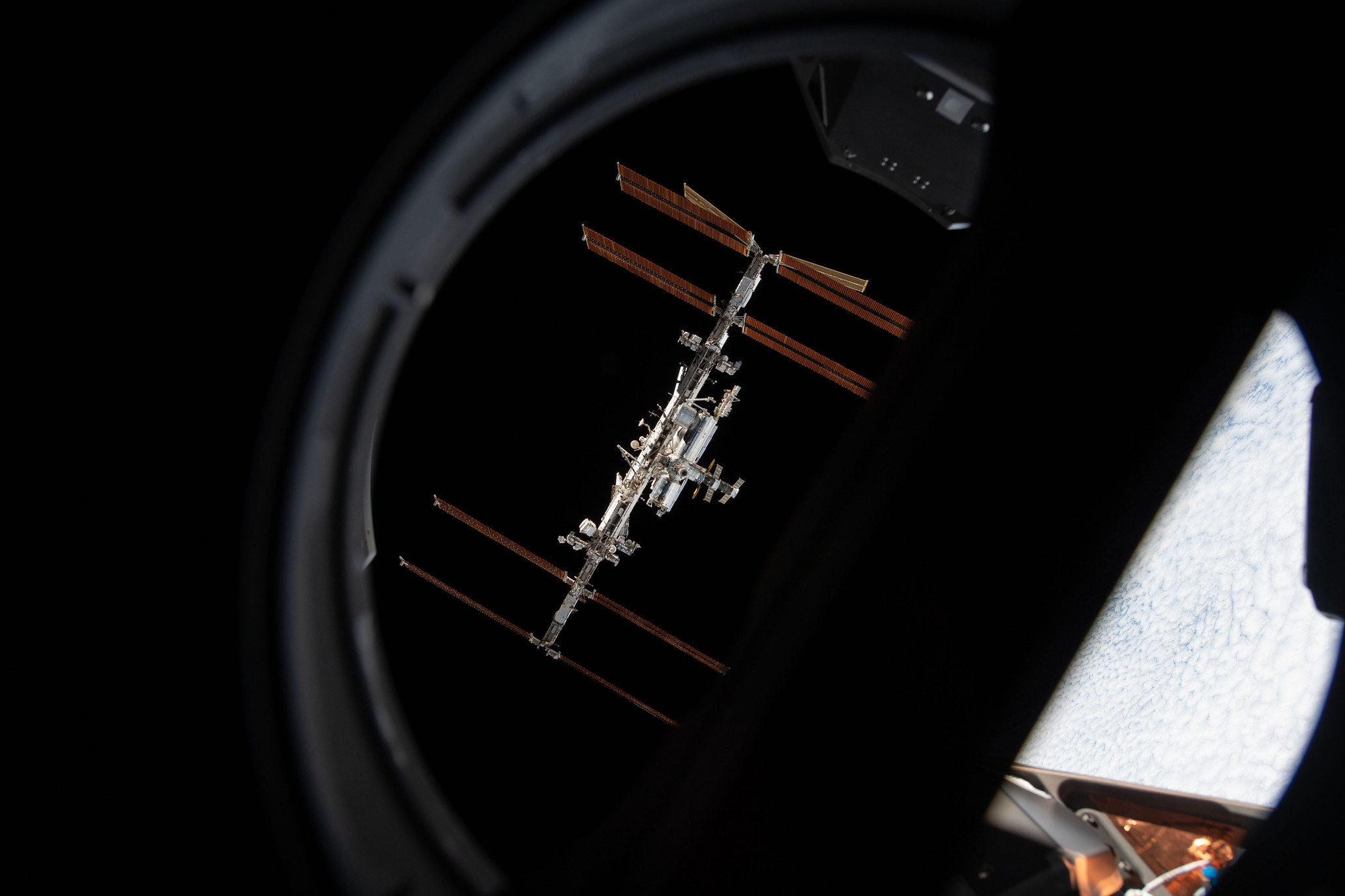 The International Space Station is pictured from inside a window aboard the SpaceX Crew Dragon Endeavour during a fly around of the orbiting lab that took place following its undocking from the Harmony module’s space-facing port on Nov. 8, 2021.