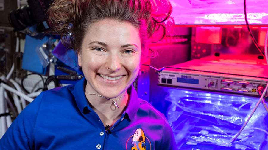Astronaut Kayla Barron poses for a portrait in front of the VEGGIE space botany facility inside the space station's Columbus laboratory module.