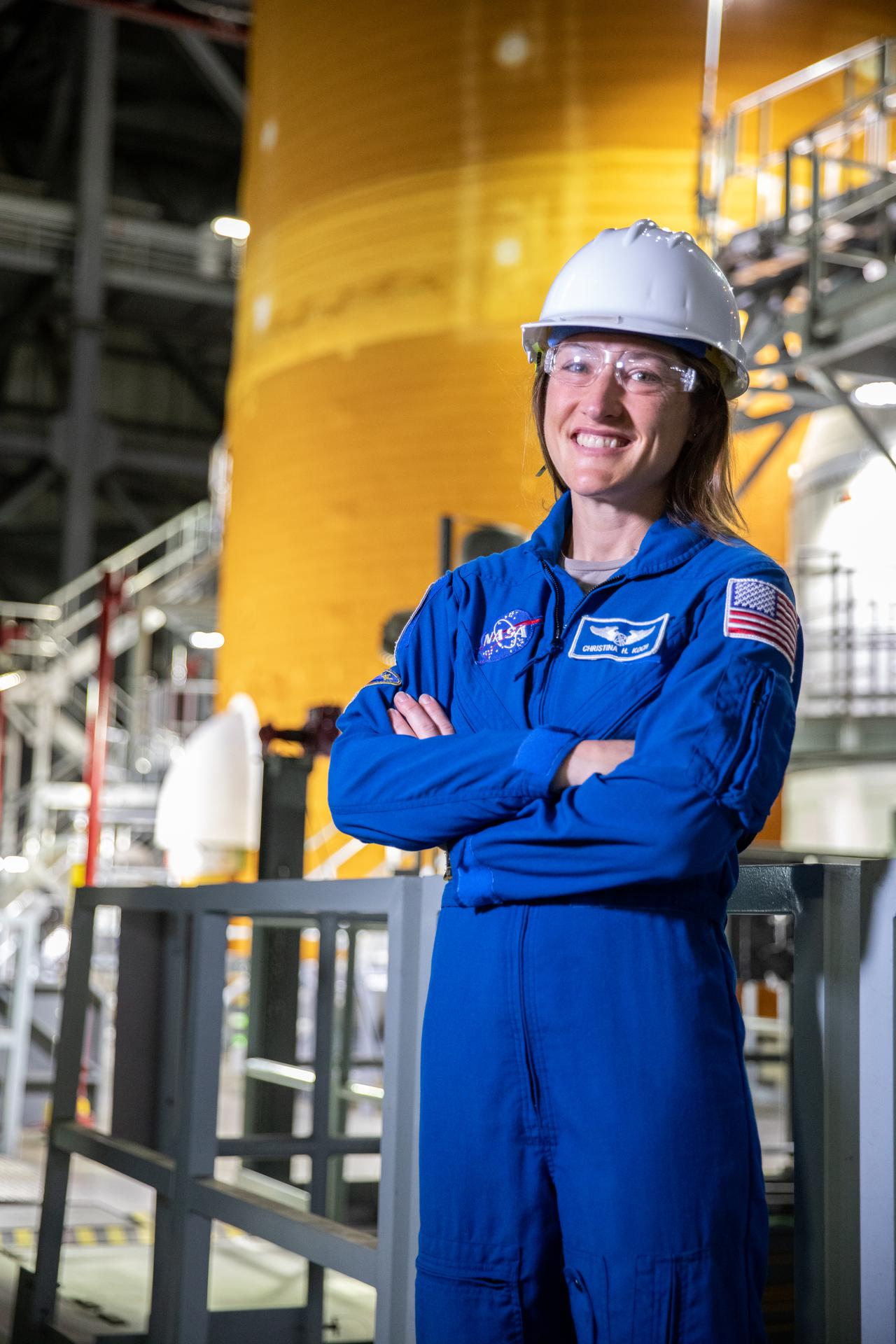 Astronaut Christina Koch stands in front of the agency’s Space Launch System (SLS) rocket