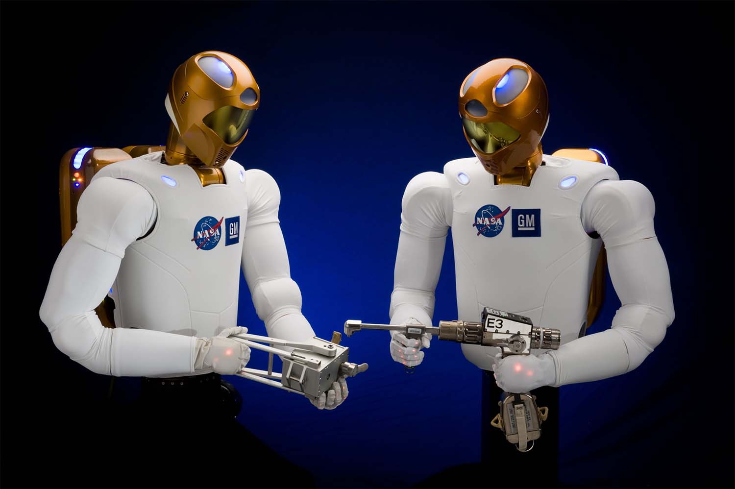 Two Robonaut models hold tools