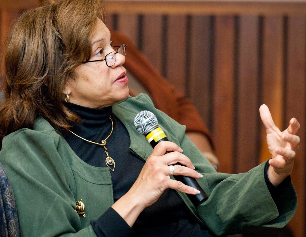 S. Jenise Veris holds a microphone and asks a question.