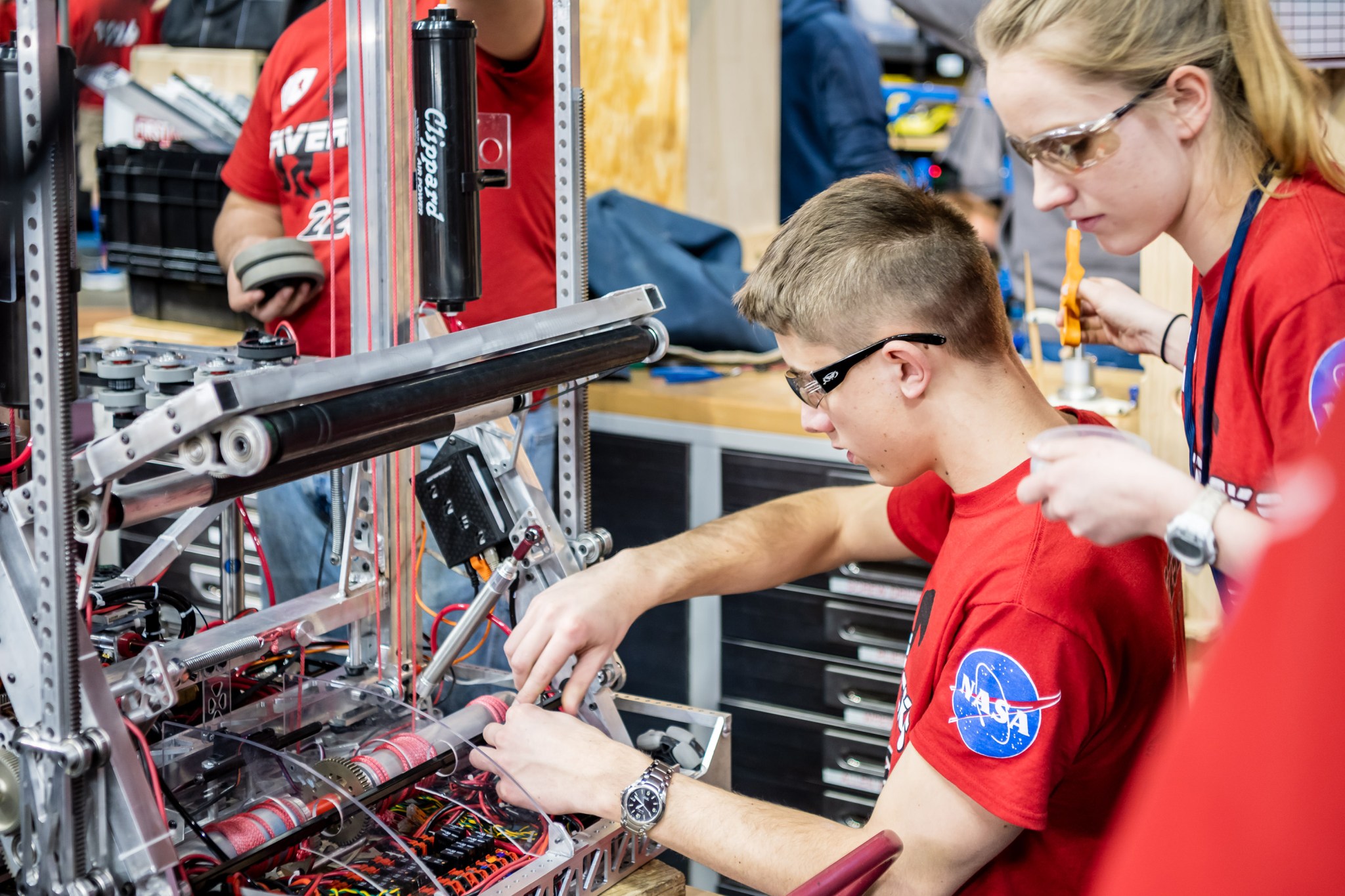 Two students on the right working on robots.