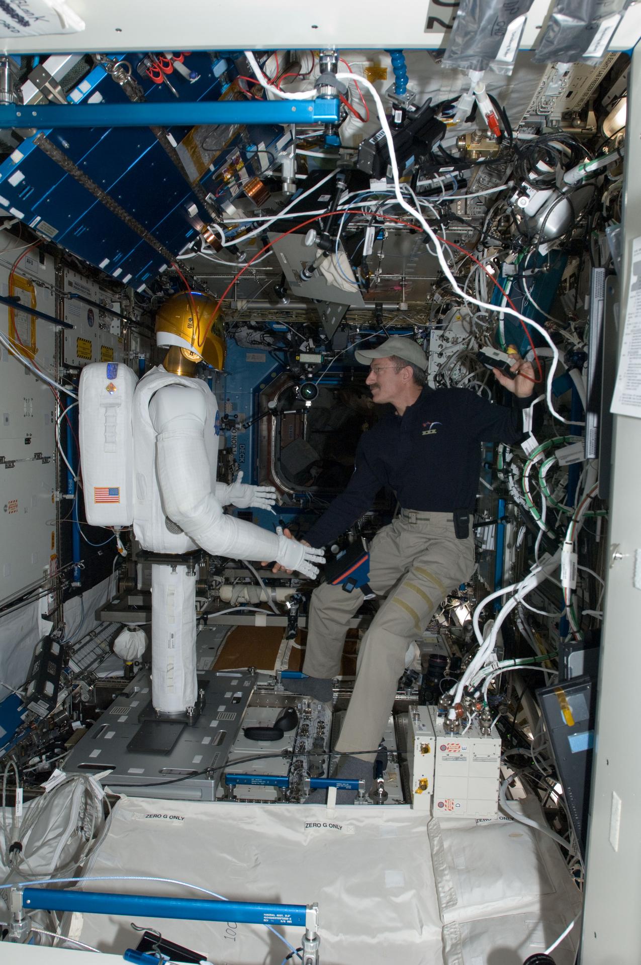 Robonaut 2 shakes hands with NASA astronaut Dan Burbank