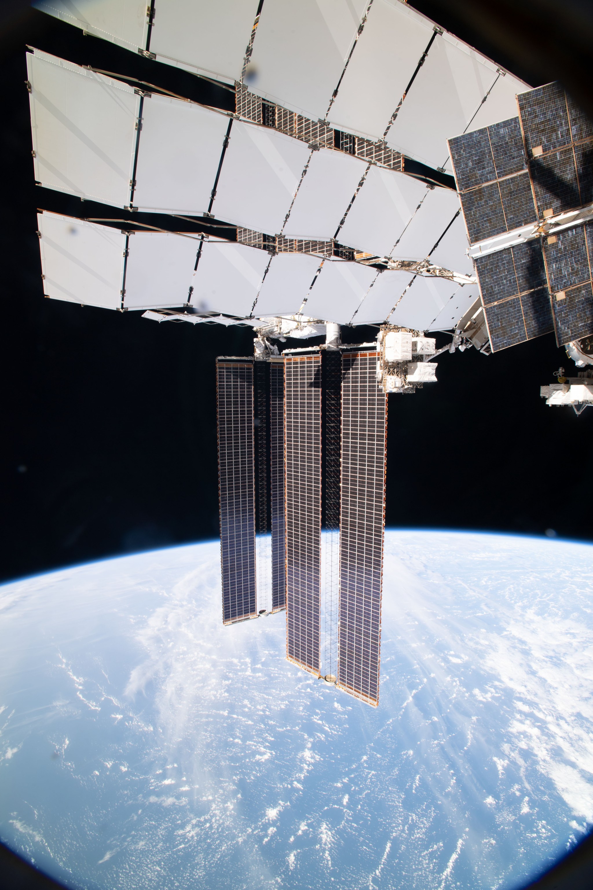 Dwarfed by the International Space Station's main solar arrays, spacewalkers Shane Kimbrough and Thomas Pesquet work to complete the installation of a roll out solar array on the P-6 truss structure. 