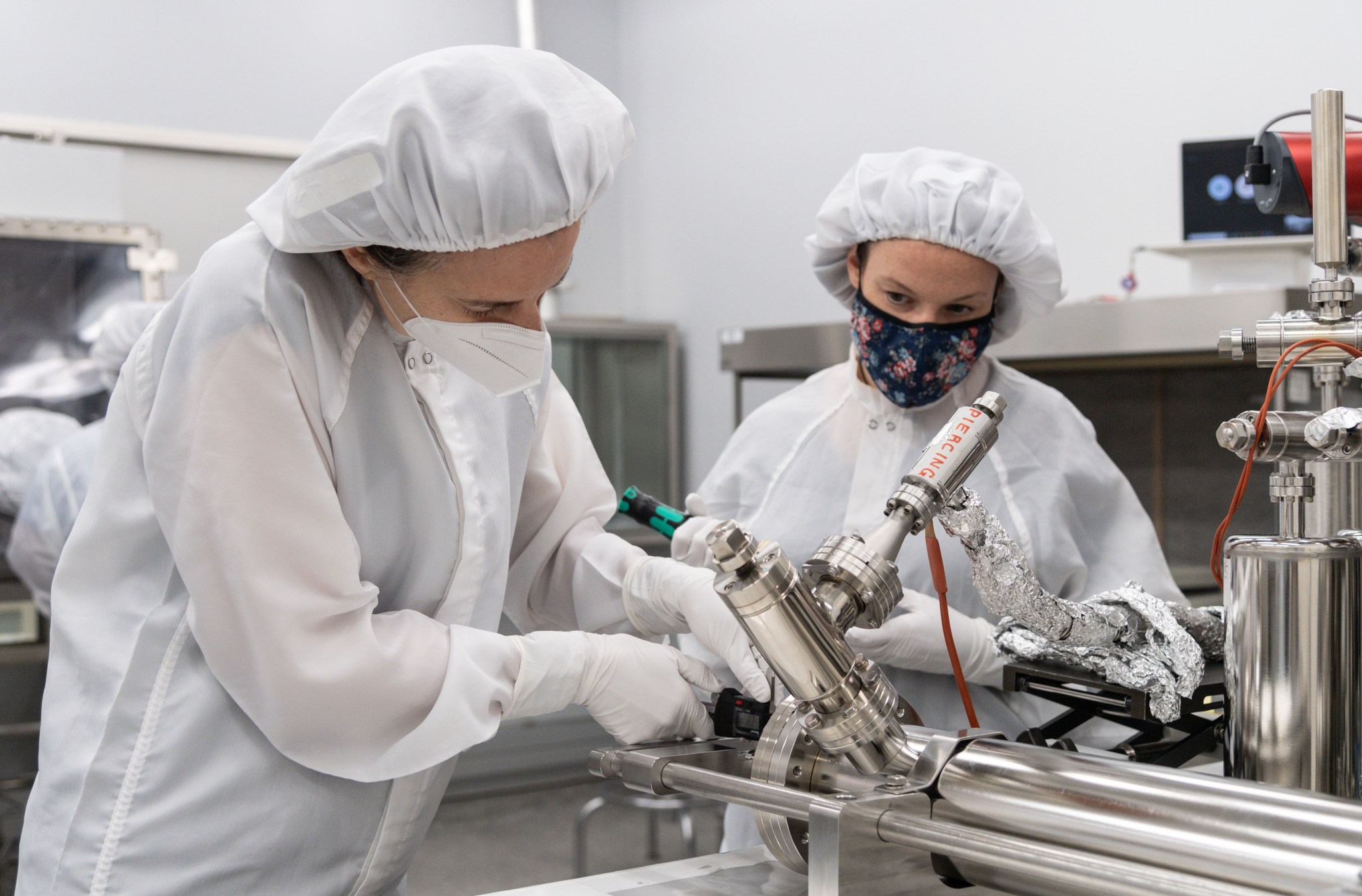From left, Dr. Juliane Gross, Astromaterials Research and Exploration Science Division (ARES) deputy Apollo curator, and Dr. Francesca McDonald, from ESA, take precise measurements from the piercing device prior to using the newly developed tool. 