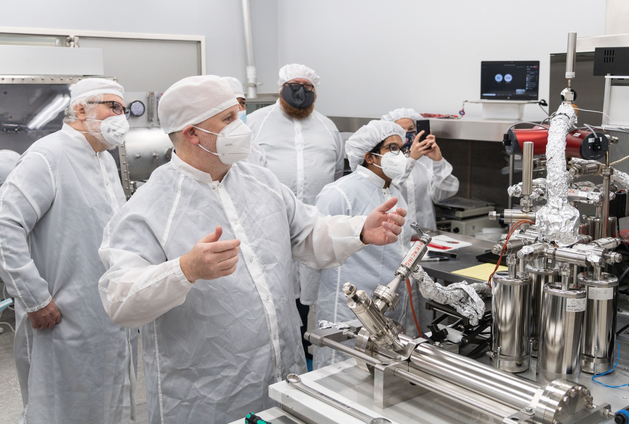 Front from left, Drs. Ryan Zeigler, Rita Parai, Francesca McDonald, Chip Shearer, back from left, Drs. Zach Sharp from University of New Mexico and Francis McCubbin, NASA astromaterials curator look on as gas is extracted after inner tube was pierced. 