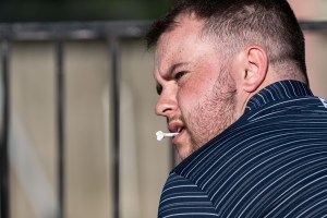 man with golf tee in mouth