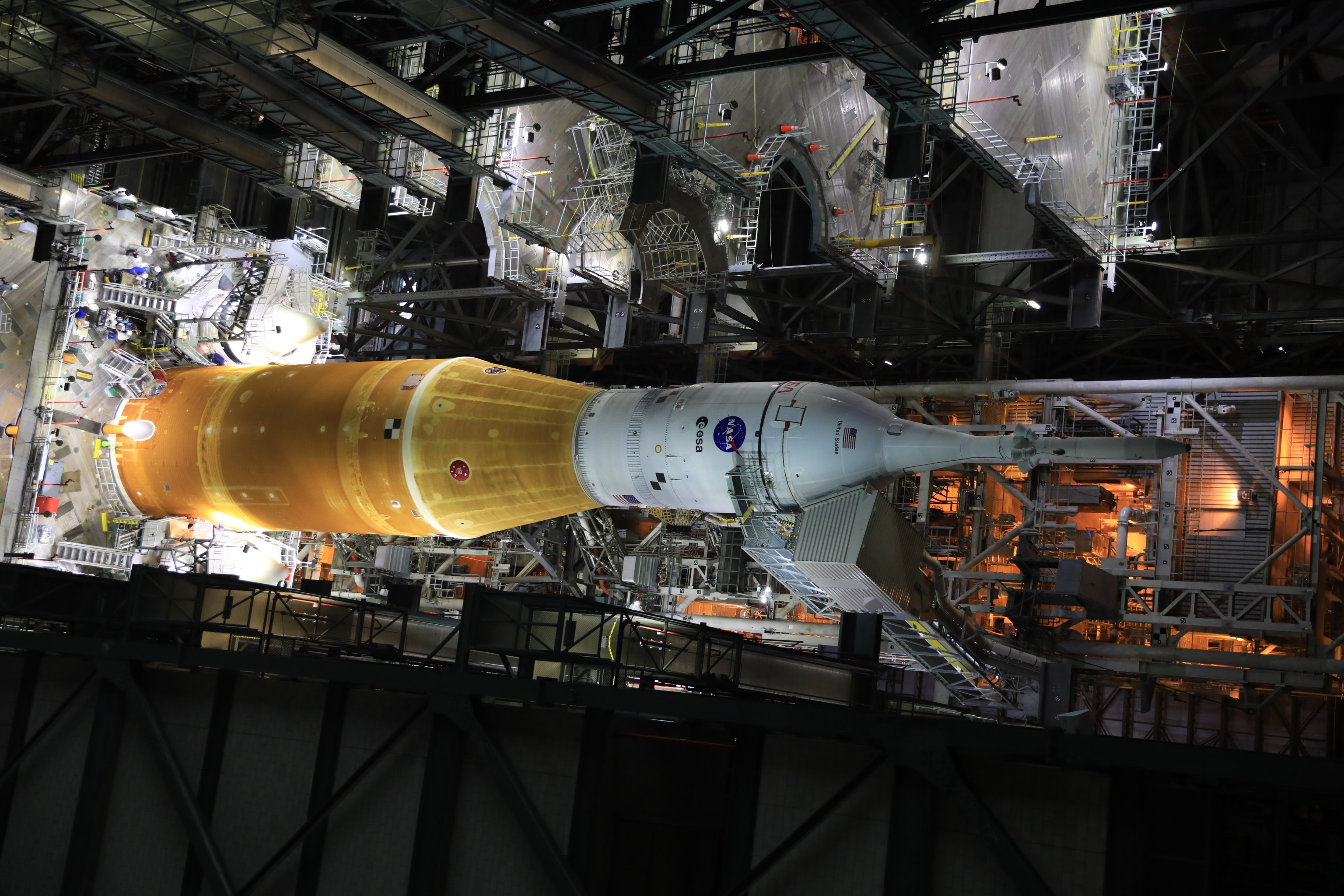 Inside the Vehicle Assembly Building at NASA’s Kennedy Space Center in Florida, work platforms are being retracted from around the Artemis I Space Launch System rocket and Orion spacecraft in preparation to roll out for testing ahead of the mission.