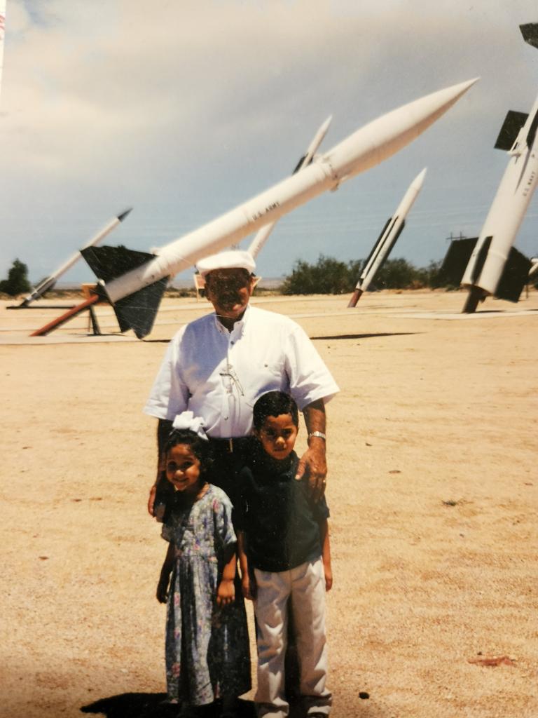 Marissa Garcia as a child with members of her family with rockets in the background.