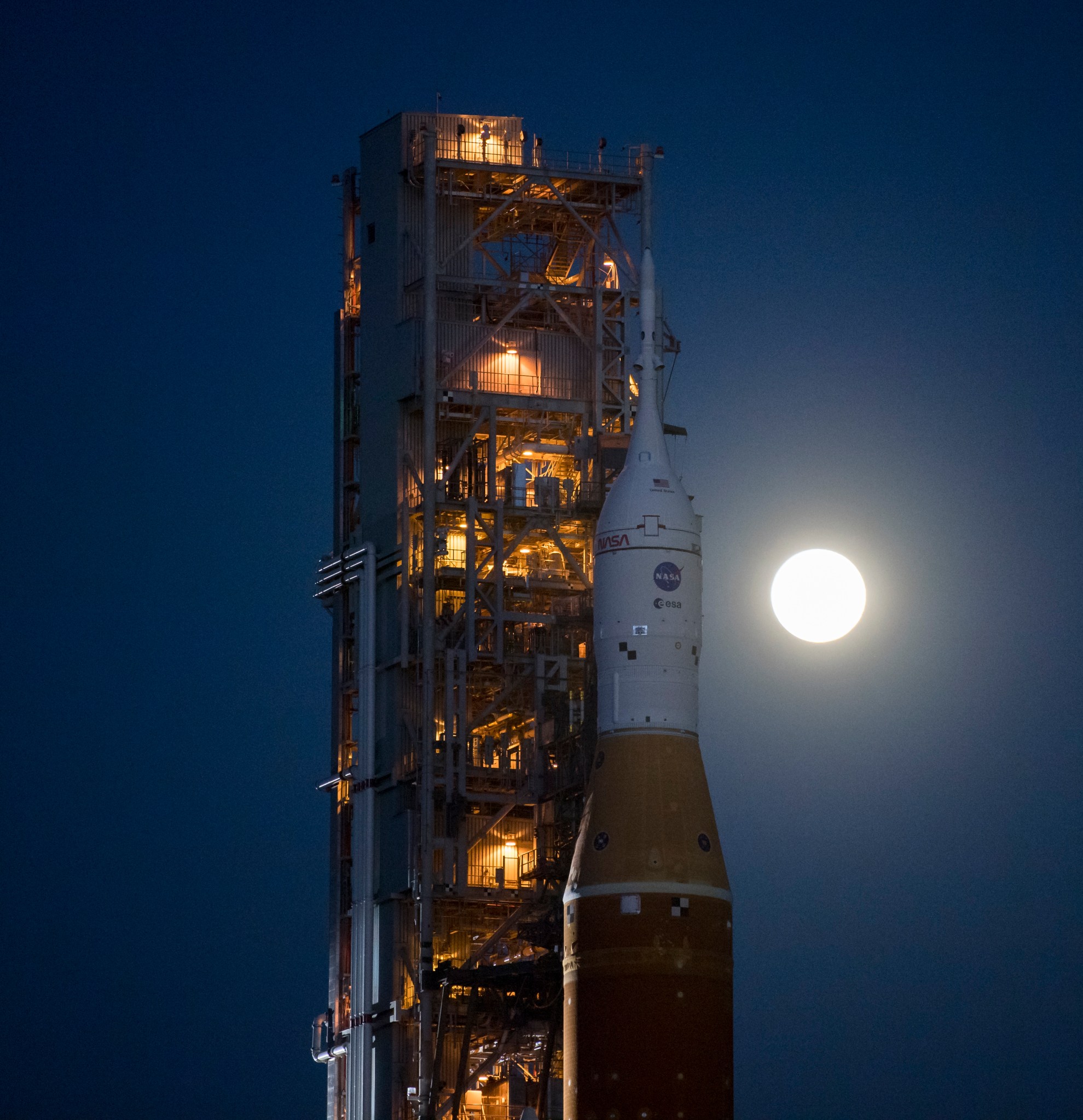 The Moon rises behind NASA's Space Launch System rocket and Orion spacecraft. 