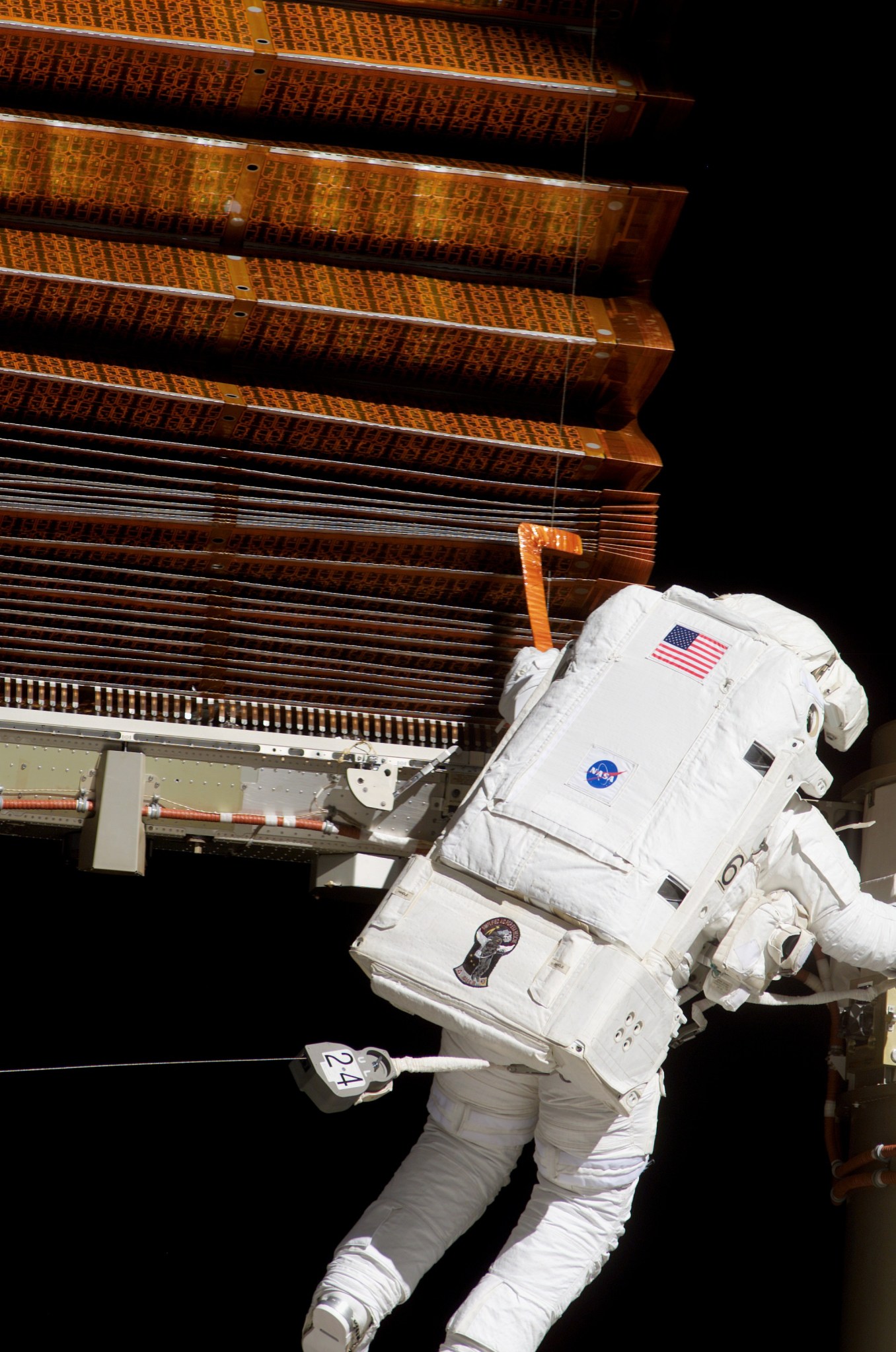 Astronaut works on solar array panel in space.