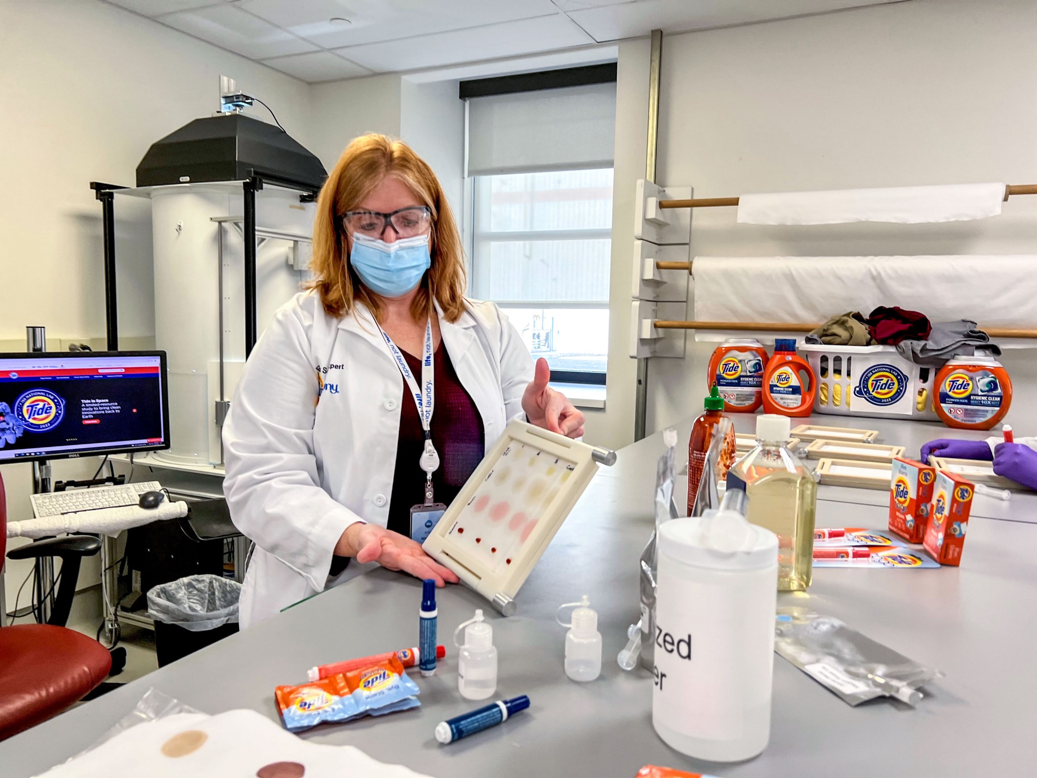 image of the scientist in a lab holding up an experiment sample