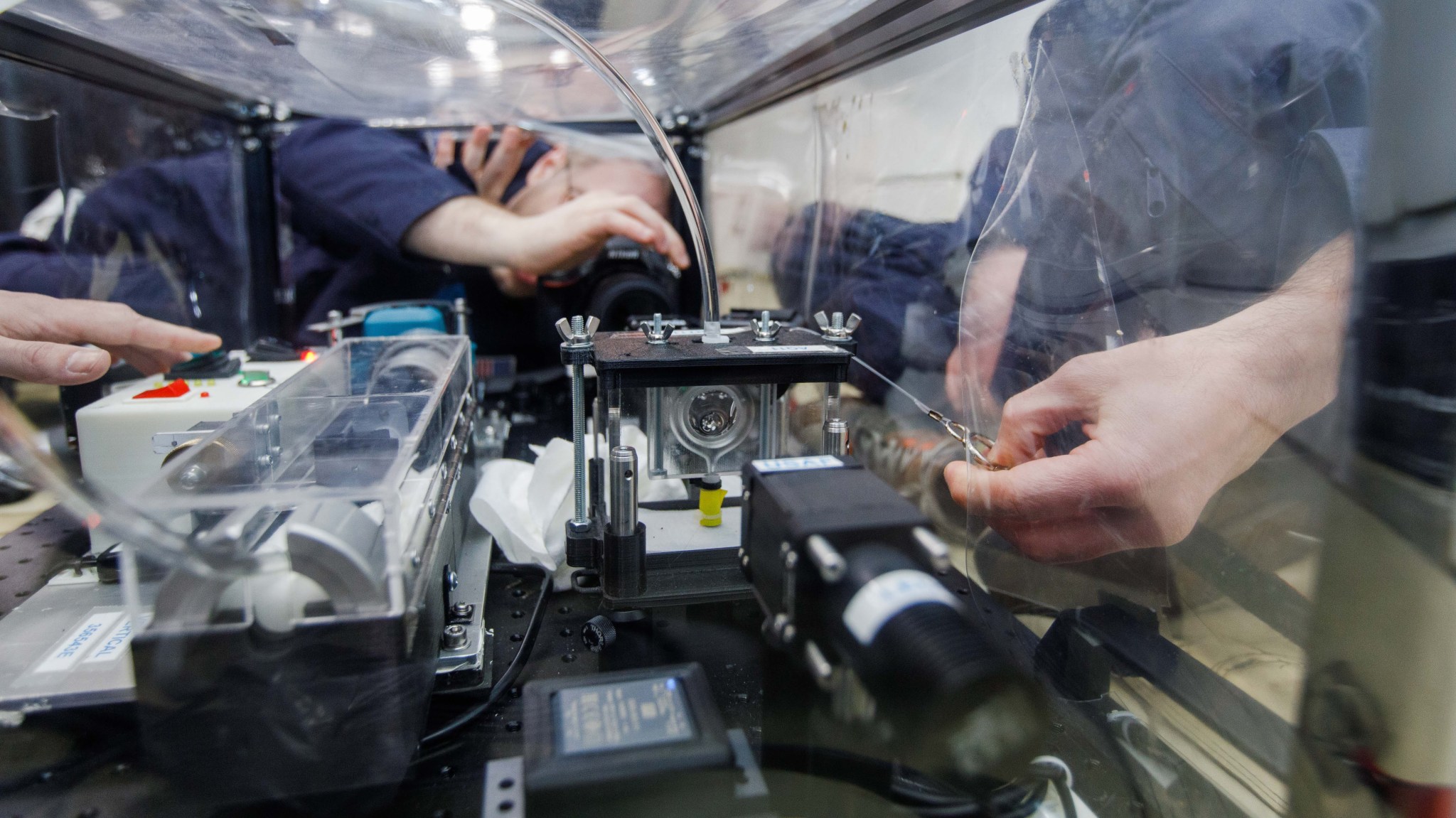 FLUTE researchers capture data while they push synthetic oil into a circular frame (about the size of a dollar coin), momentarily forming a liquid lens during a 15 to 20-second period of microgravity on a ZeroG parabolic flight.
