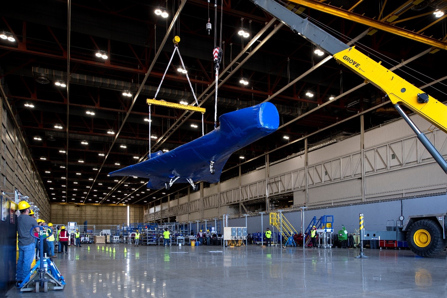 Aircraft suspended in air inside hangar.