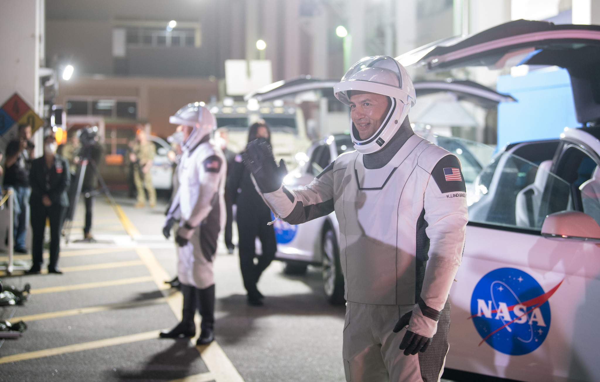 NASA astronaut Kjell Lindgren waves to family and friends as he and crew mates, NASA astronauts Robert Hines, Jessica Watkins, and ESA (European Space Agency) astronaut Samantha Cristoforetti, wearing SpaceX spacesuits, depart the Neil A. Armstrong Operations and Checkout Building for Launch Complex 39A to board the SpaceX Crew Dragon spacecraft for the Crew-4 mission launch, Tuesday, April 26, 2022, at NASA’s Kennedy Space Center in Florida.
