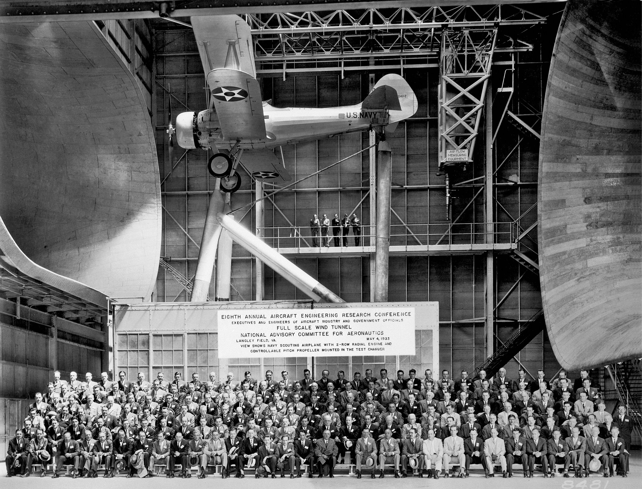 Attendees at the 8th Annual Aircraft Engineering Research Conference in May of 1933 sit below a U.S. 