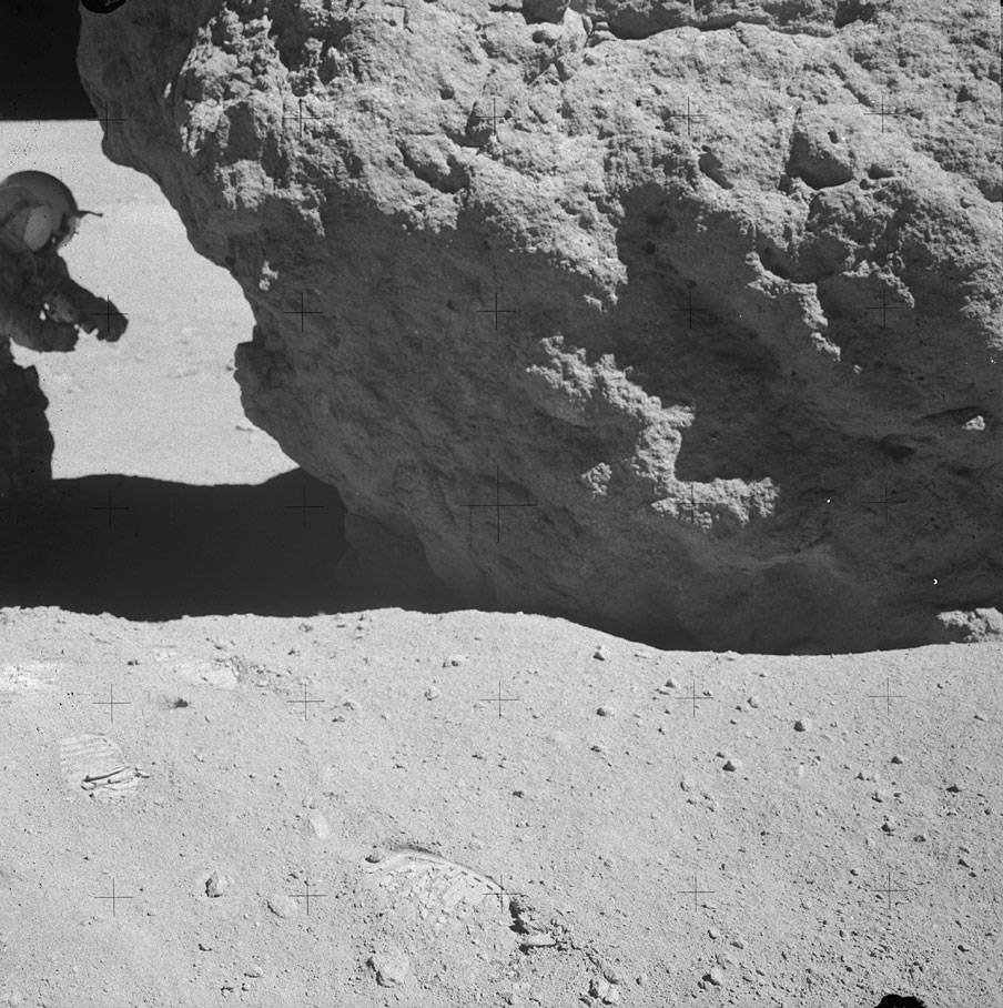 apollo_16_landing_eva3_sta_13_young_looking_under_shadow_rock