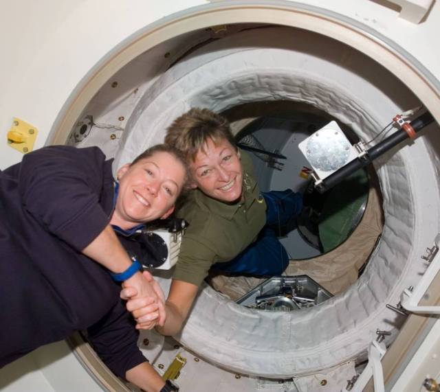 Expedition 16 Commander Peggy Whitson greets STS-120 Commander Pam Melroy after hatch opening between the ISS and the orbiter Discovery