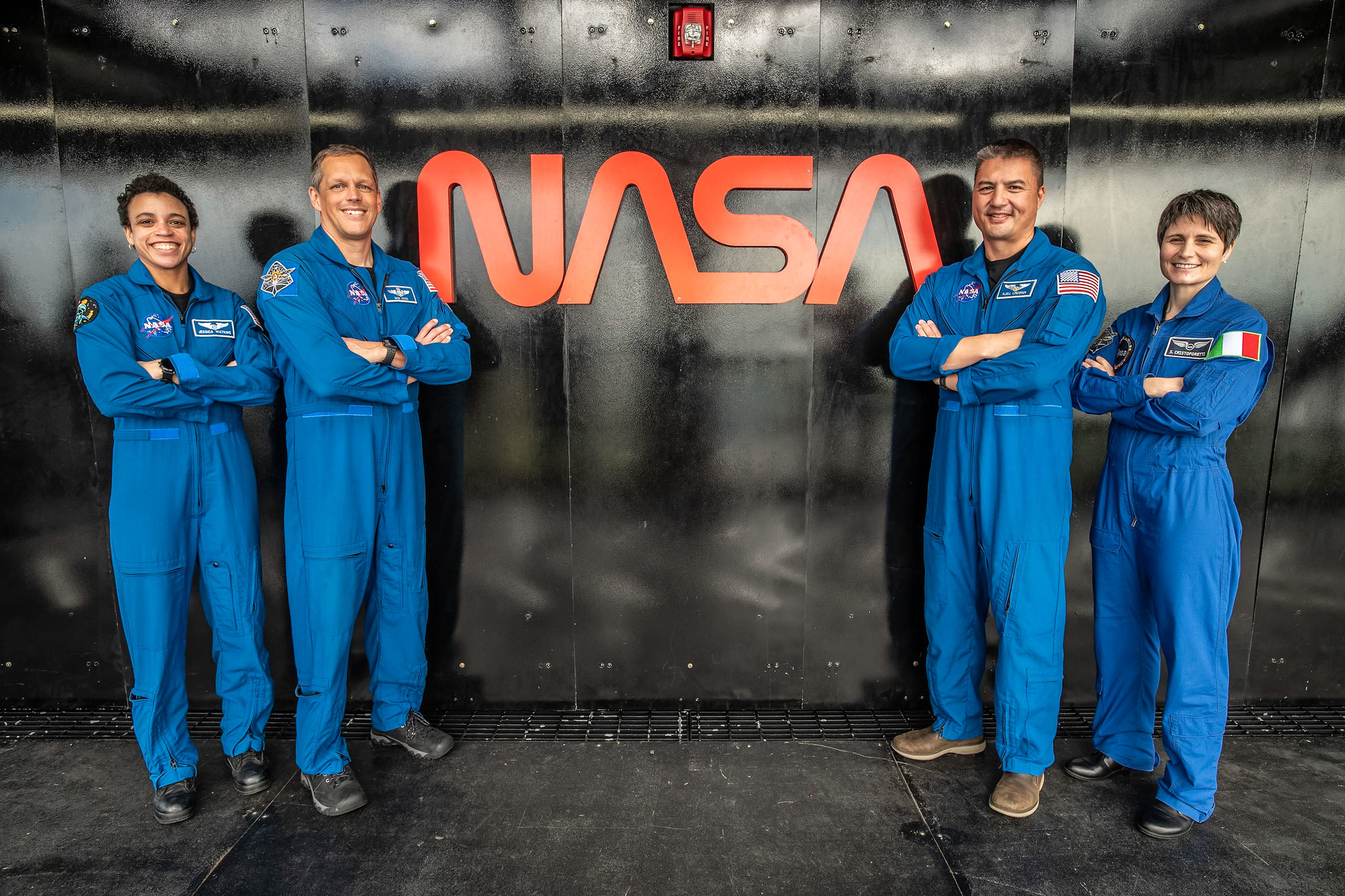 NASA's Crew-4 astronauts pose for a photo in front of the NASA worm logo.