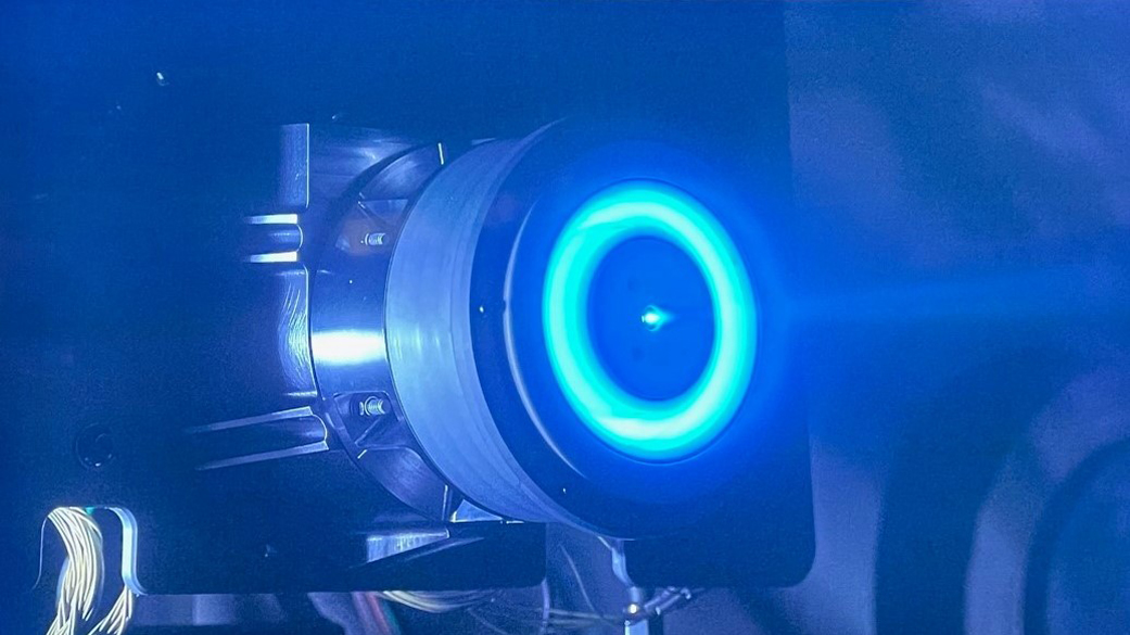 A disc glowing blue on an electric propulsion thruster.