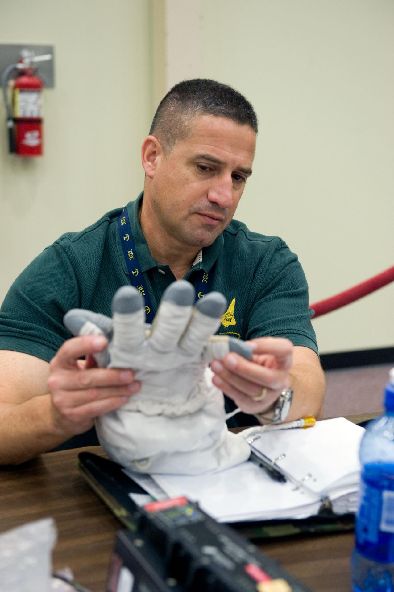JSC2009-E-244194 (23 Nov. 2009) --- Astronaut George Zamka, STS-130 commander, examines an Extravehicular Mobility Unit (EMU) glove during a training session in the Space Vehicle Mockup Facility at NASA's Johnson Space Center.