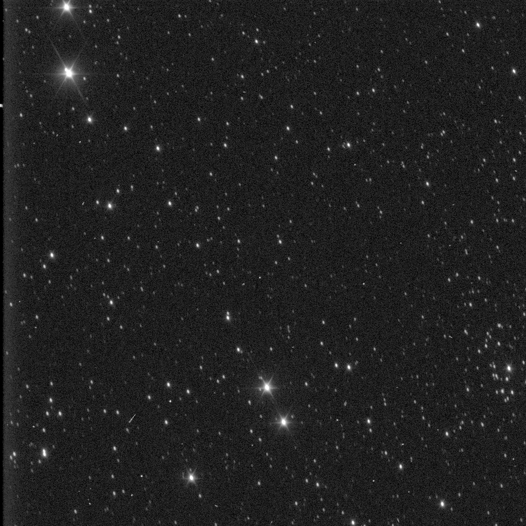 Slightly grainy black-and-white view of stars. In the top left and bottom center, a few stars glow brightly with six pointed diffraction spikes.