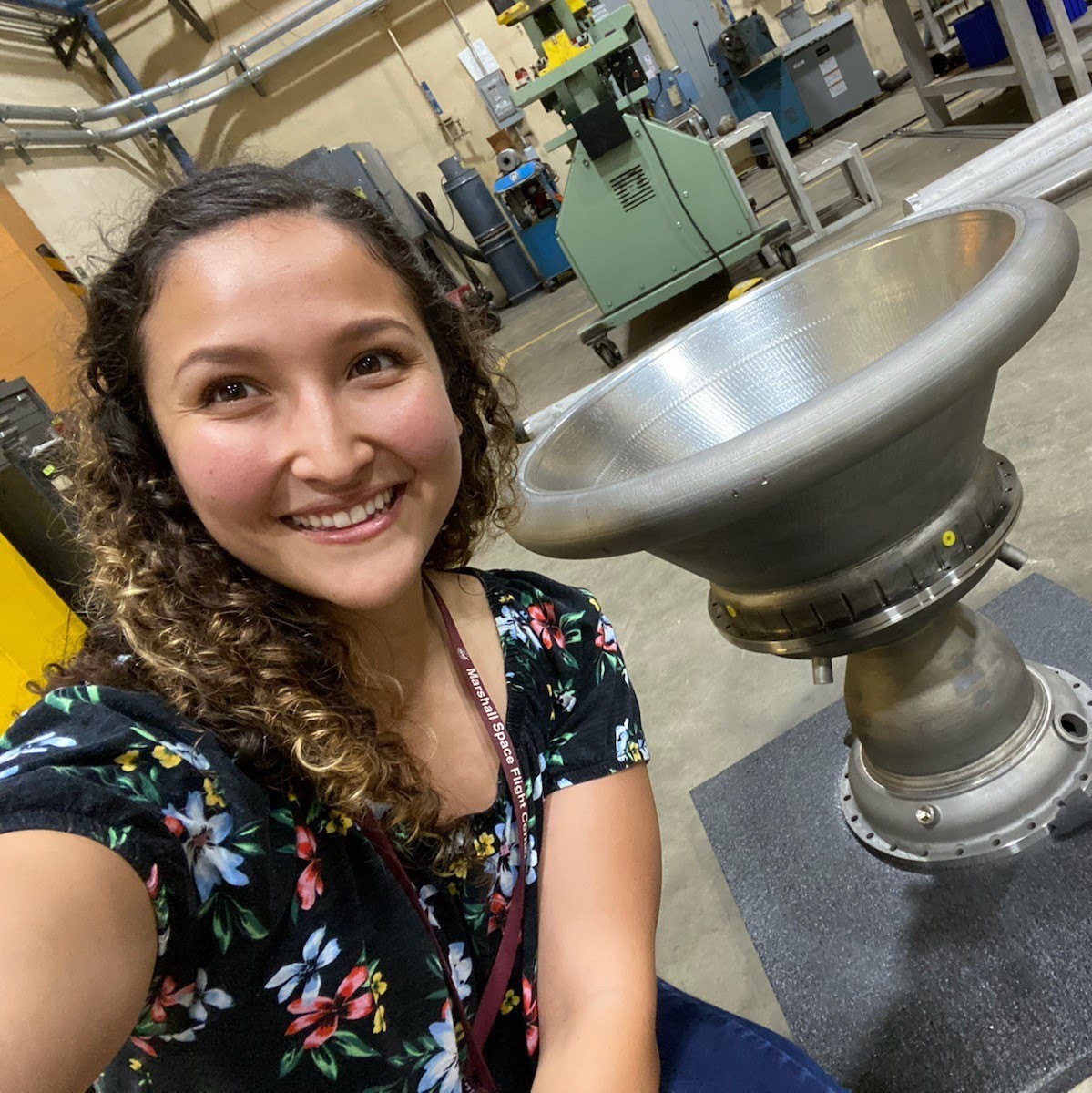 Marissa Garcia in front of machinery she's working with.