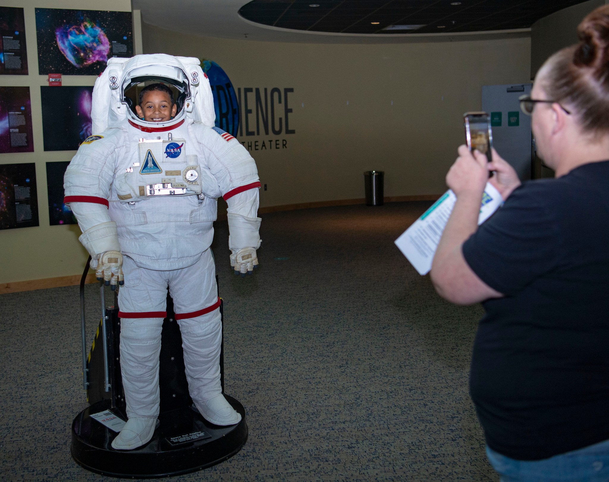 A young visitor “tries on” a NASA spacesuit at INFINITY Science Center.