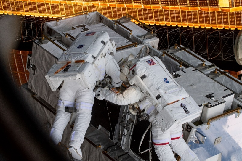 An image of two astronauts using the Simplified Aid for EVA Rescue (SAFER)