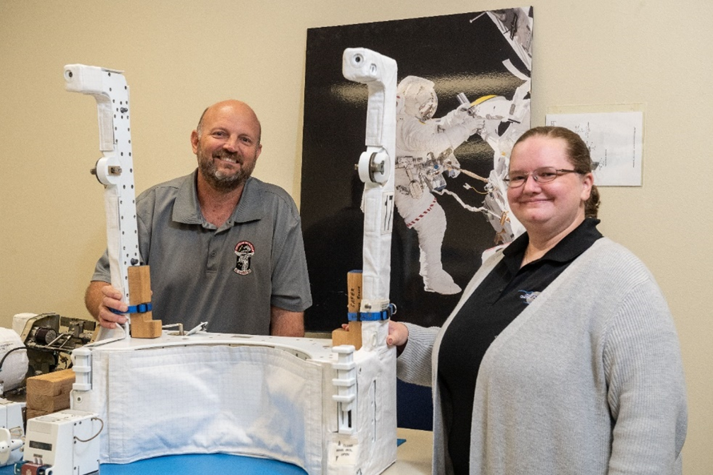 An image of two people displaying the simplified Aid for EVA Rescue (SAFER)