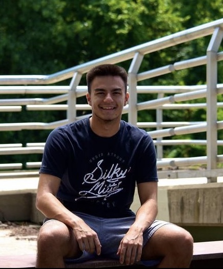 Seth Usher sitting on bleachers outside.