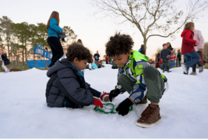 Children playing in snow at 2022 Jingle and Mingle event