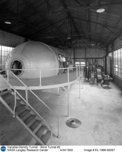This is a photo of two engineers working on the not-yet-in-operation Variable Density Tunnel in 1922. The interior of the tunnel was through the open door seen at the end of the tank.