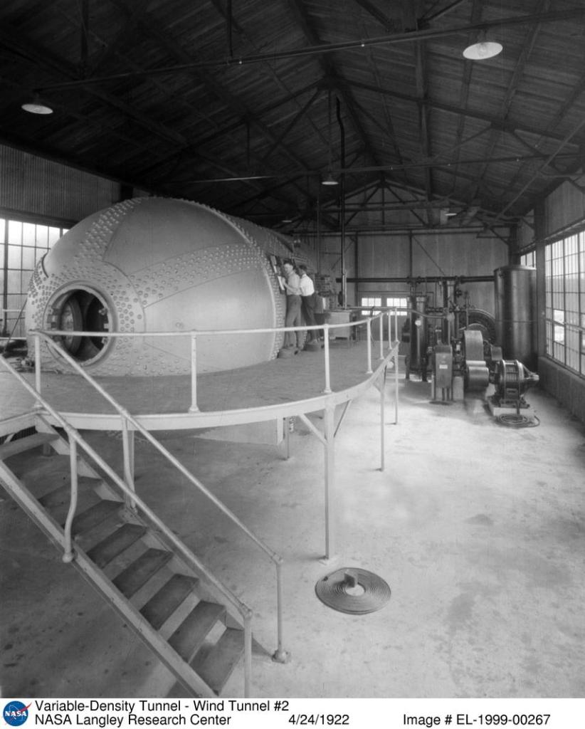 This is a photo of two engineers working on the not-yet-in-operation Variable Density Tunnel in 1922. The interior of the tunnel was through the open door seen at the end of the tank.