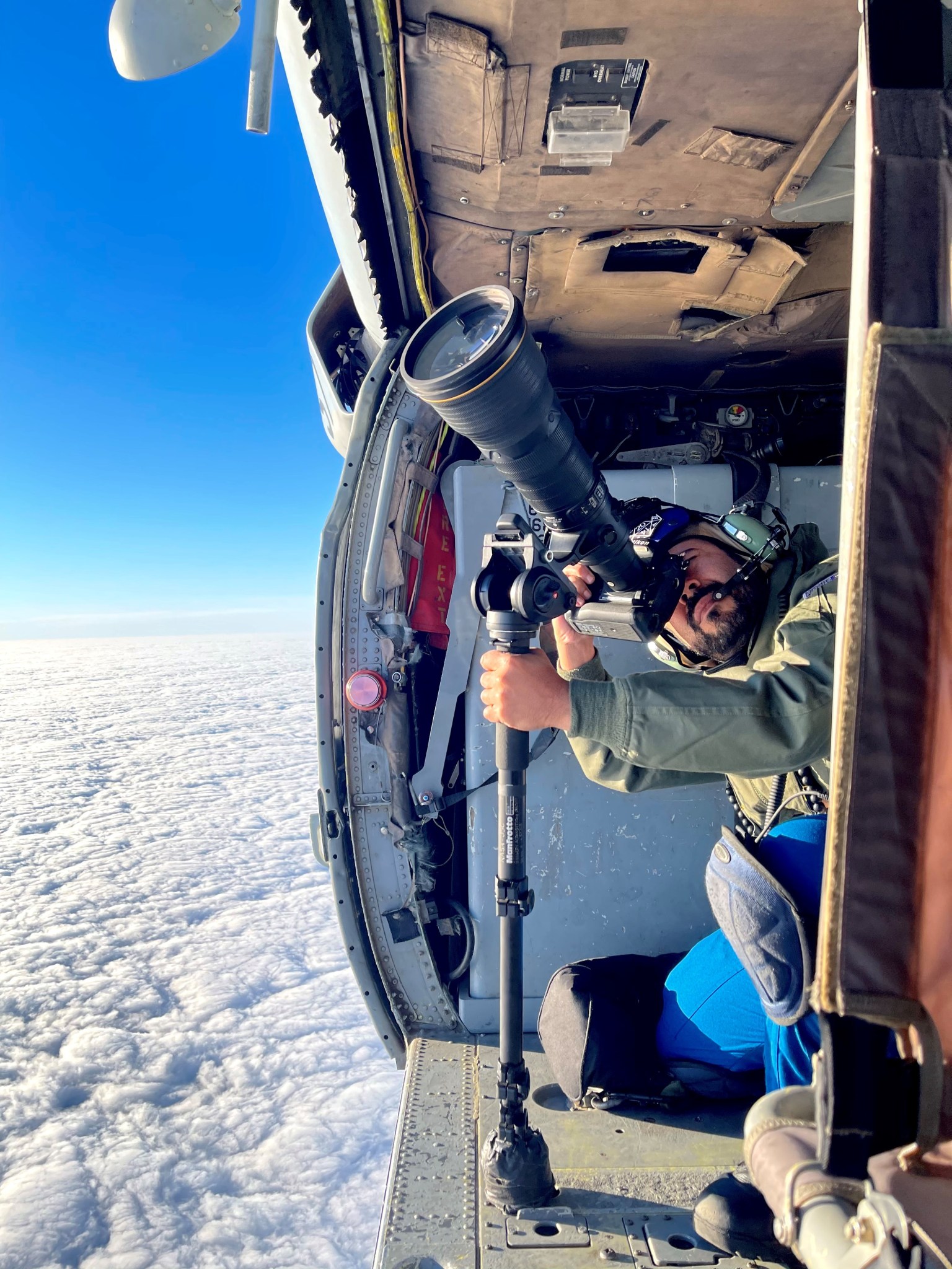 NASA Scientific Photographer Josh Valcarcel taking photos from a helicopter cabin