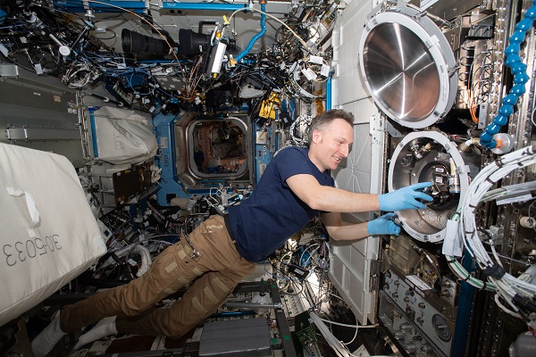 image of an astronaut working on experiment hardware