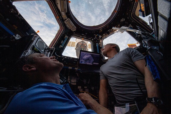 image of two astronauts gazing out cupola windows