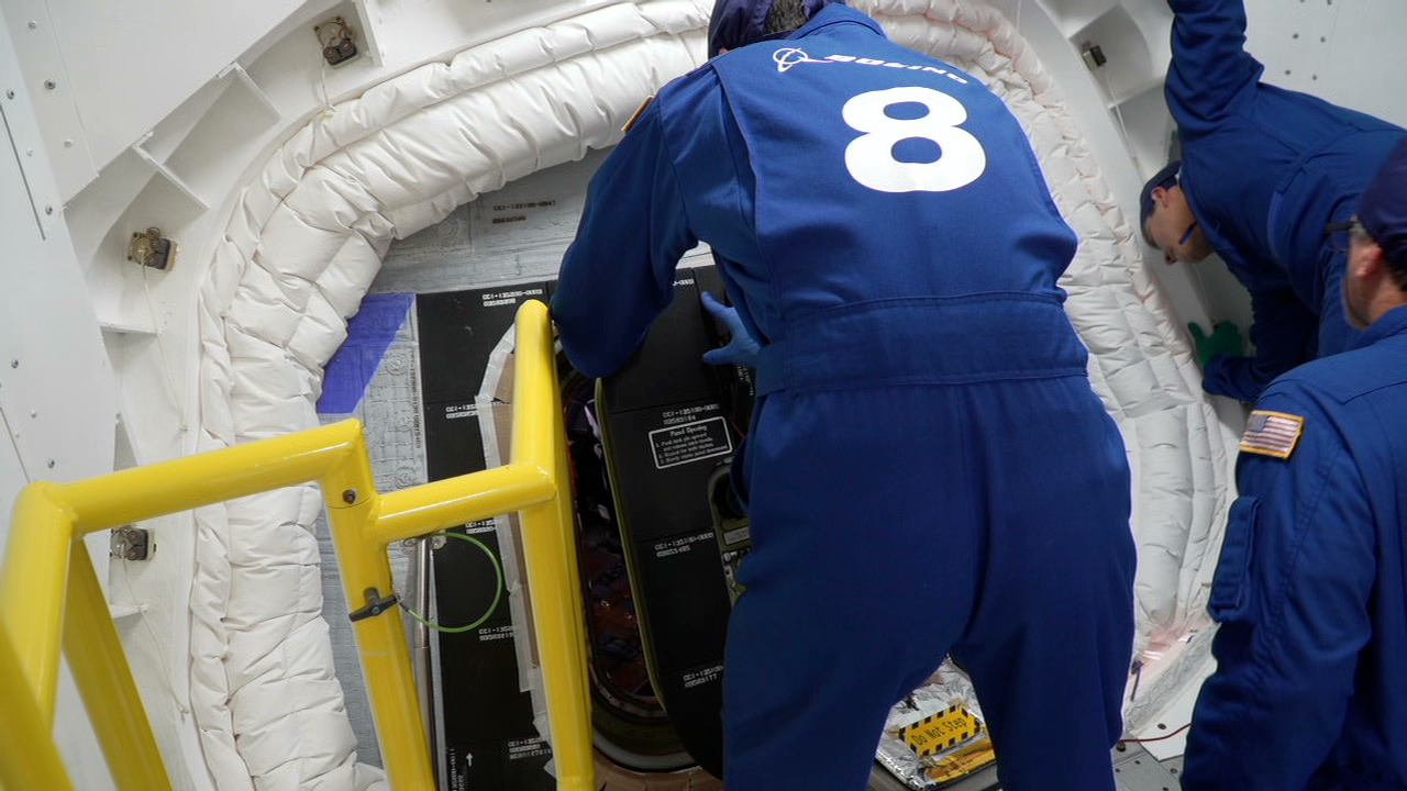 Boeing close-out specialists secure the hatch on the Boeing CST-100 Starliner at Space Launch Complex-41 at Cape Canaveral Space Force Station in Florida on May 19, 2022, ahead of launch.