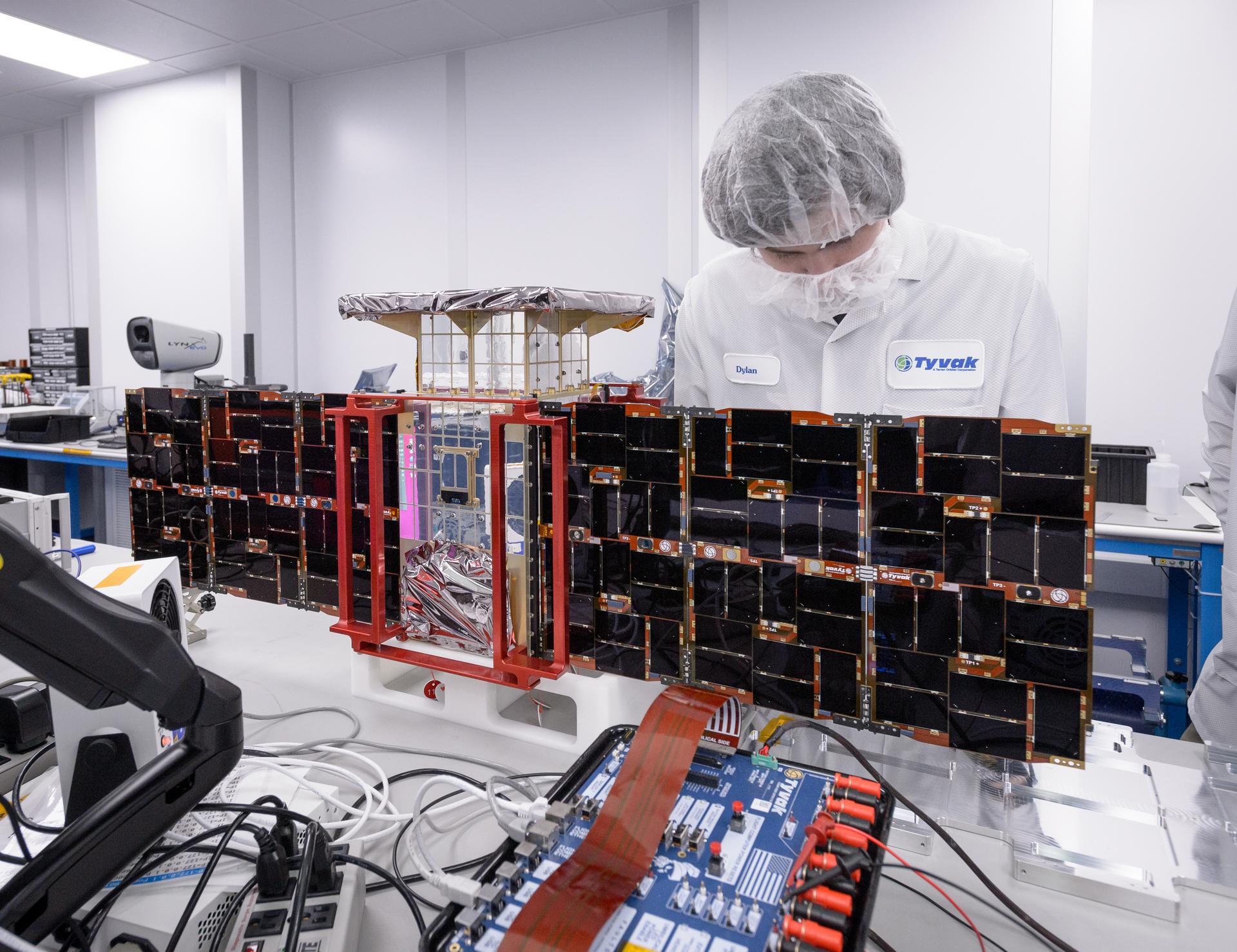 Here, a team member installs solar panels onto the CAPSTONE spacecraft – short for Cislunar Autonomous Positioning System Technology Operations and Navigation Experiment – before its launch to the Moon.